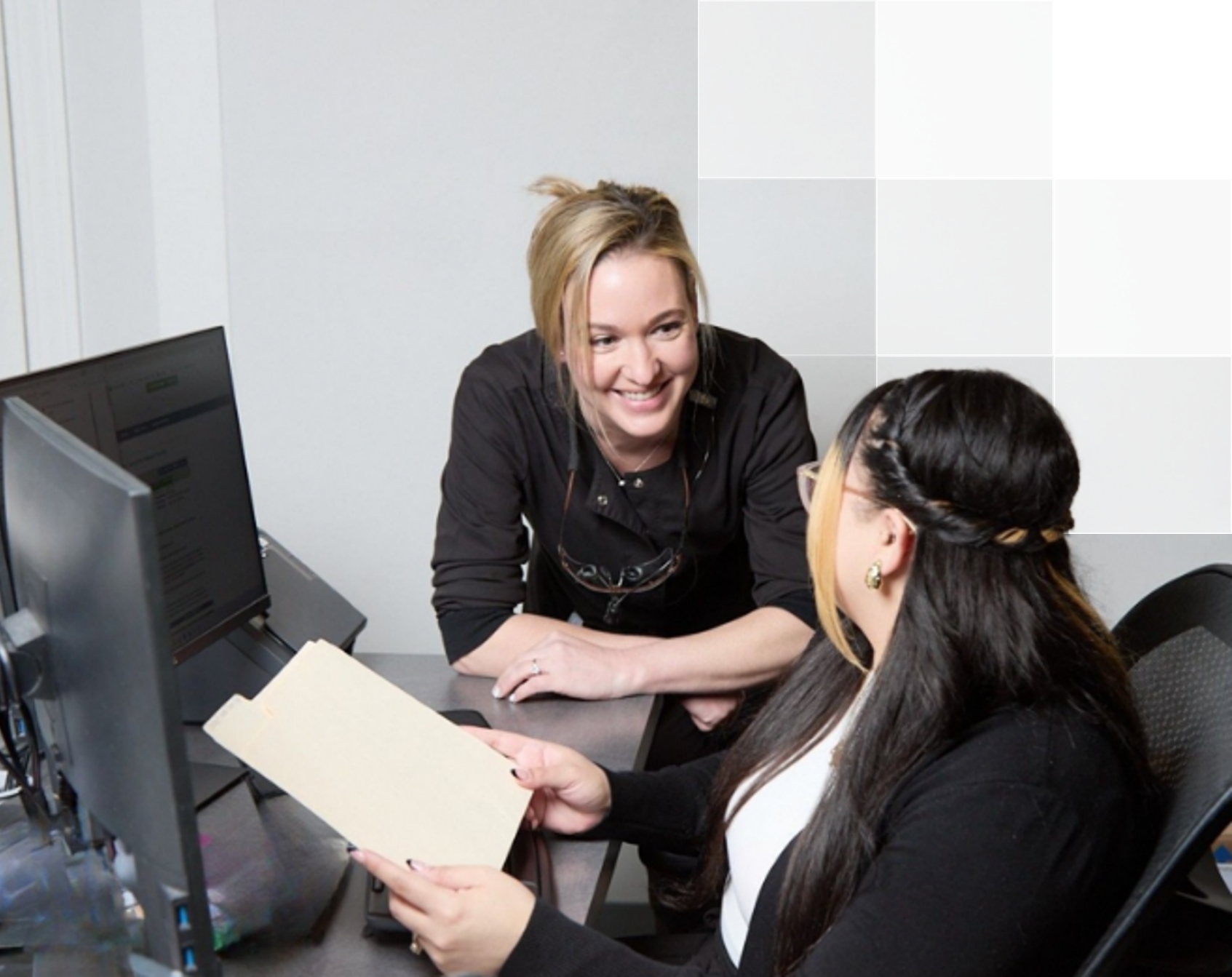 Women coworkers smiling in dental office.